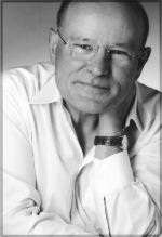 Josef Fellsches, Foto: Sibylle Ostermann Schwarzweissportrait von Josef Fellsches im weissen Hemd, der linke Ellenbogen ruht auf dem rechten Arm, die linke Hand fasst den Nacken. Kopf leicht schräg, freundlicher Blick. Foto: Sibylle Ostermann
